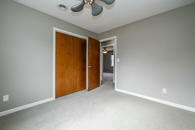 unfurnished bedroom with light carpet, ceiling fan, and a closet