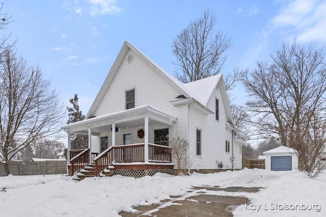 view of front facade featuring an outbuilding, a garage, and covered porch