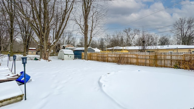 yard layered in snow with a storage unit