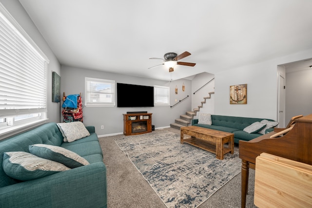 carpeted living room featuring a fireplace and ceiling fan