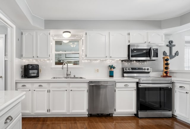 kitchen featuring dark hardwood / wood-style floors, sink, white cabinets, backsplash, and stainless steel appliances