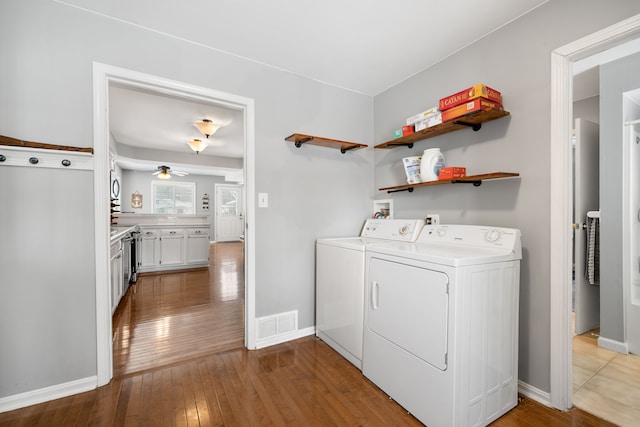 laundry area with ceiling fan, independent washer and dryer, and light hardwood / wood-style flooring