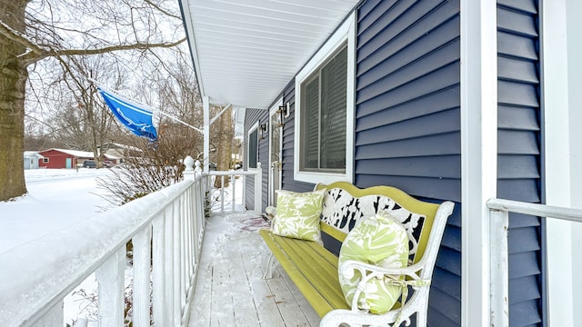 view of snow covered back of property