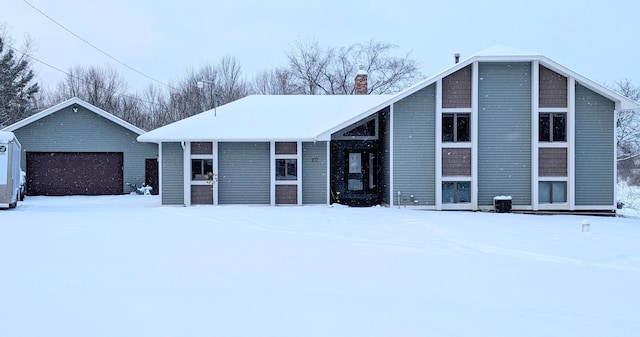 view of front of property featuring a chimney and a detached garage