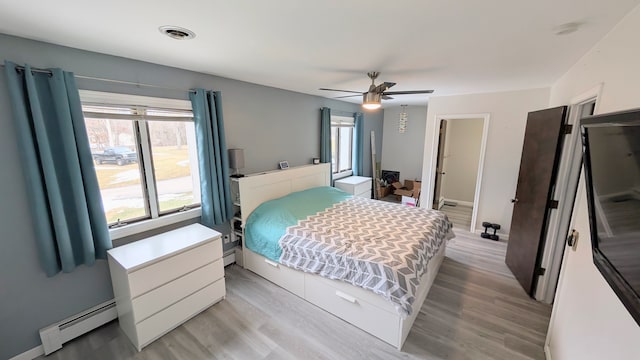 bedroom featuring visible vents, baseboards, a ceiling fan, a baseboard radiator, and light wood-style flooring