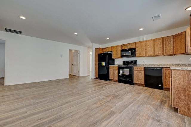 kitchen with light hardwood / wood-style floors and black appliances