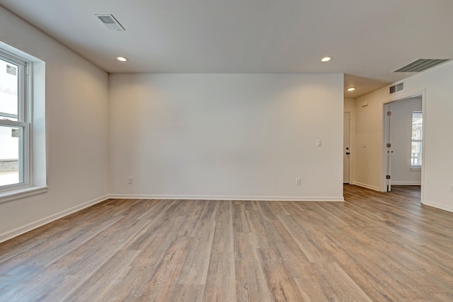 spare room with plenty of natural light and light hardwood / wood-style floors