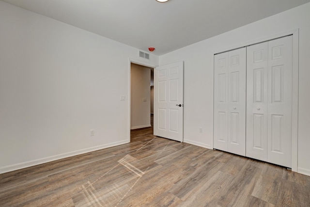 unfurnished bedroom featuring hardwood / wood-style flooring and a closet