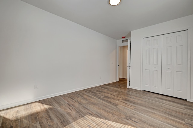 unfurnished bedroom featuring a closet and light wood-type flooring