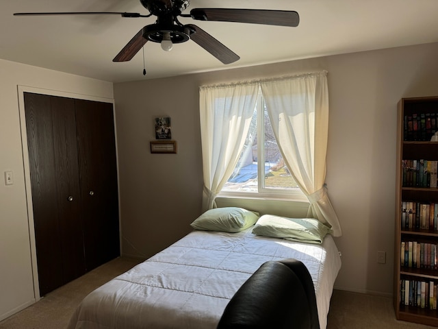 bedroom featuring ceiling fan, a closet, and light carpet