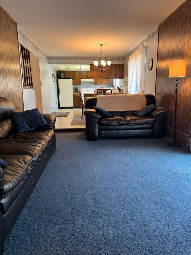 living room featuring a notable chandelier, carpet, and wood walls