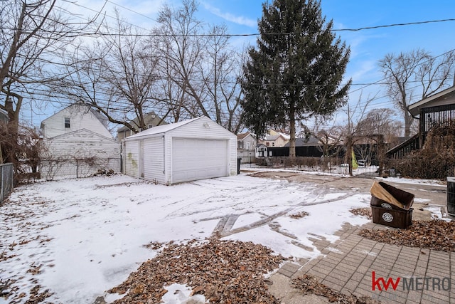 yard covered in snow with a garage and an outdoor structure