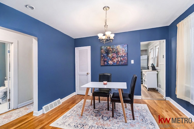 dining space featuring an inviting chandelier and light hardwood / wood-style floors