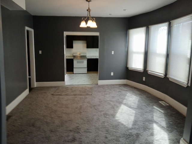 unfurnished dining area with an inviting chandelier and carpet