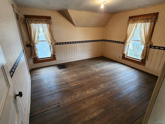 additional living space featuring dark wood-type flooring and a wealth of natural light