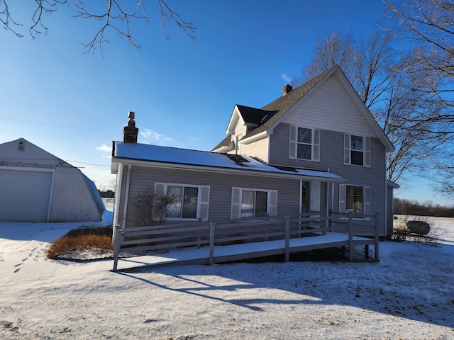 snow covered property with an outbuilding and a garage