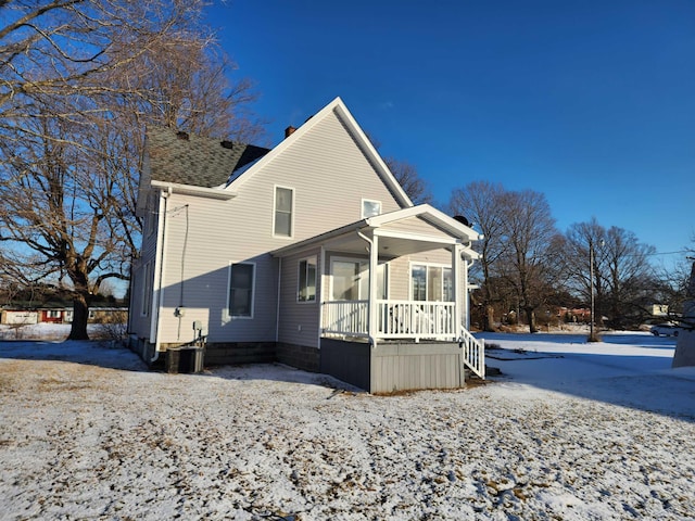 snow covered property with a porch