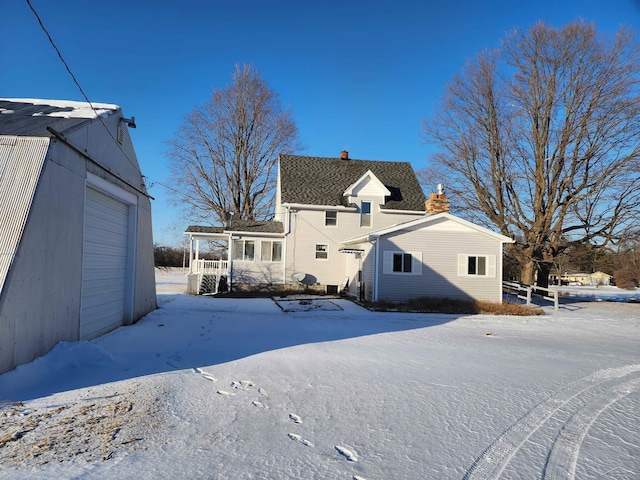 view of snow covered back of property