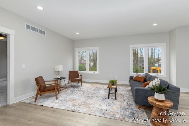 living area featuring recessed lighting, baseboards, visible vents, and wood finished floors
