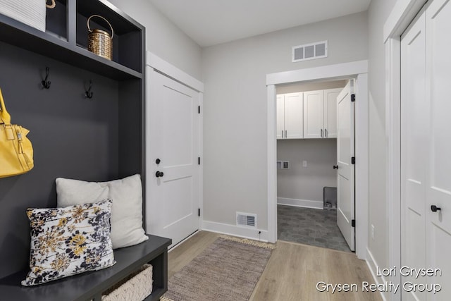 mudroom with visible vents, baseboards, and wood finished floors