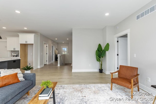 living room with recessed lighting, baseboards, visible vents, and light wood-style floors
