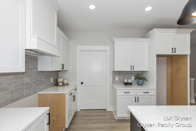 kitchen featuring light wood-style floors, recessed lighting, white cabinets, and tasteful backsplash