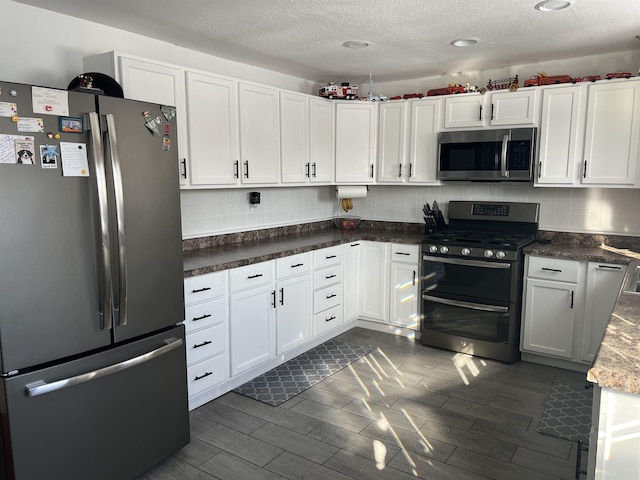 8017 S Saginaw St, New Lothrop, MI 48460 - kitchen featuring appliances with stainless steel finishes, decorative backsplash, a textured ceiling, white cabinets, and wood finish floors
