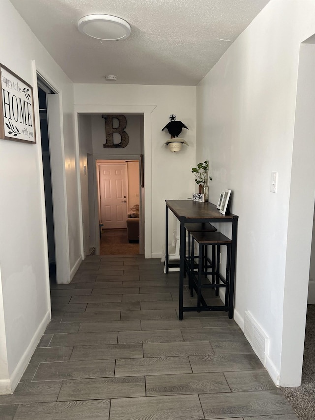 hallway with a textured ceiling