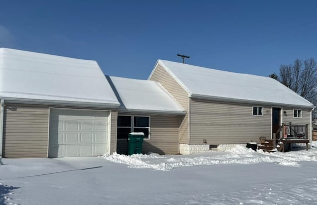 view of snow covered exterior featuring a garage