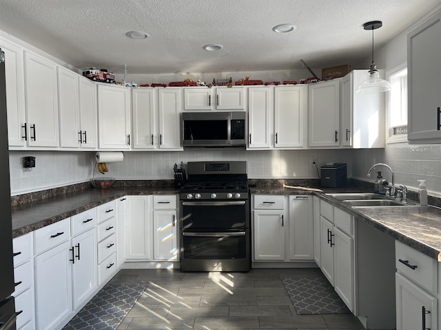 8017 S Saginaw St, New Lothrop, MI 48460 - kitchen with stainless steel appliances, a sink, a textured ceiling, white cabinets, and tasteful backsplash