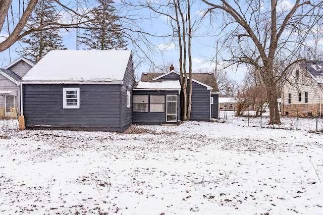 view of snow covered back of property