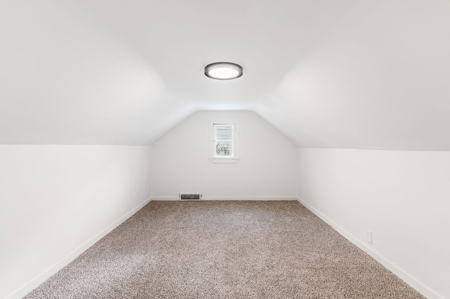 additional living space with lofted ceiling and carpet flooring