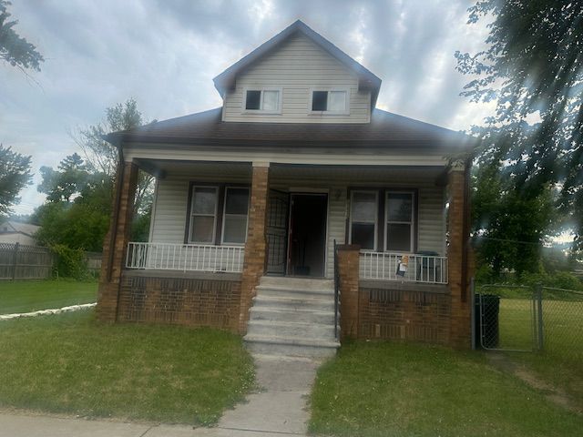 bungalow-style home featuring a front yard and covered porch