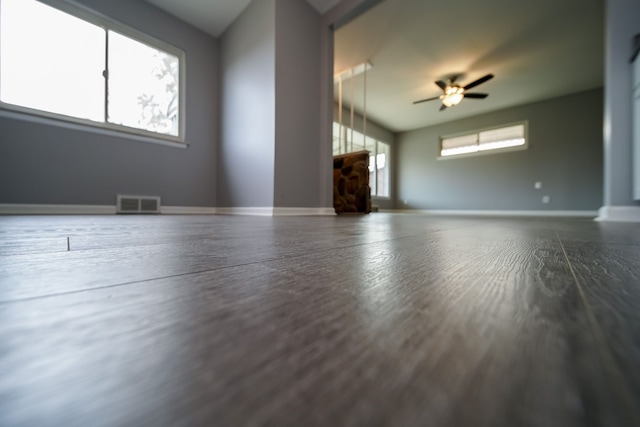 unfurnished living room featuring wood-type flooring and ceiling fan