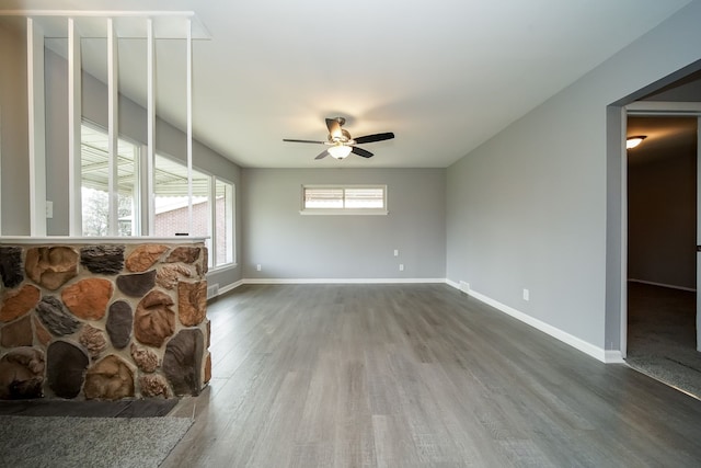 unfurnished living room with dark wood-type flooring and ceiling fan