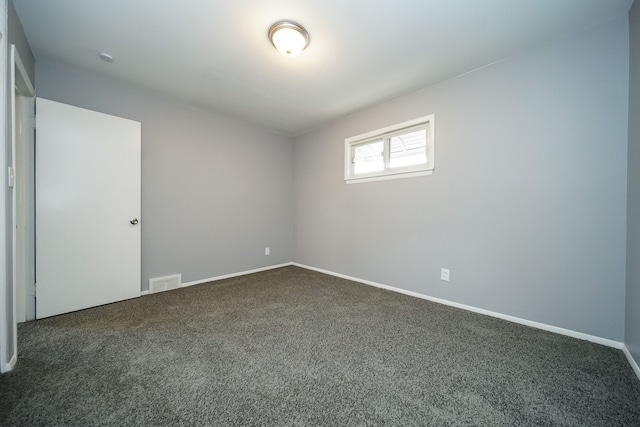 unfurnished room featuring dark carpet