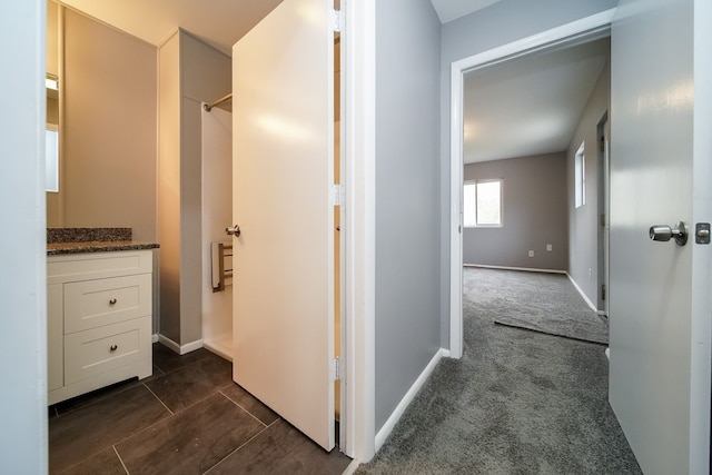 hallway featuring dark carpet