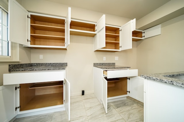 kitchen with dark stone counters and white cabinets