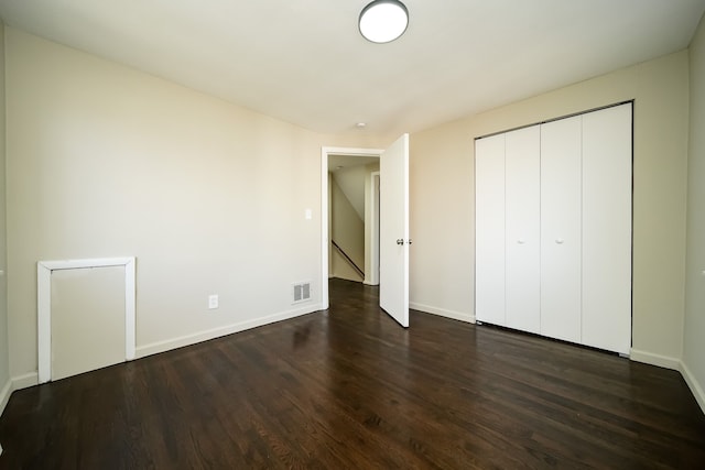 unfurnished bedroom featuring dark hardwood / wood-style flooring and a closet