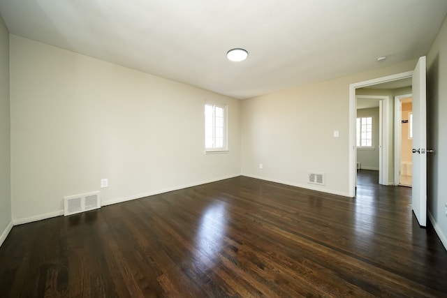 unfurnished room with a wealth of natural light and dark hardwood / wood-style floors