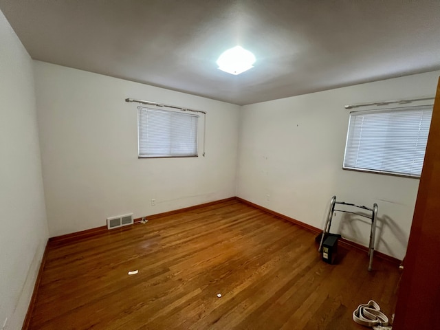 unfurnished room with hardwood / wood-style flooring