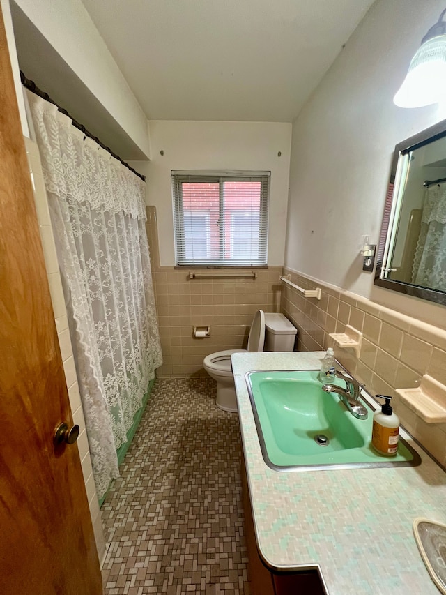 bathroom featuring toilet, a shower with curtain, tile walls, tile patterned floors, and vanity