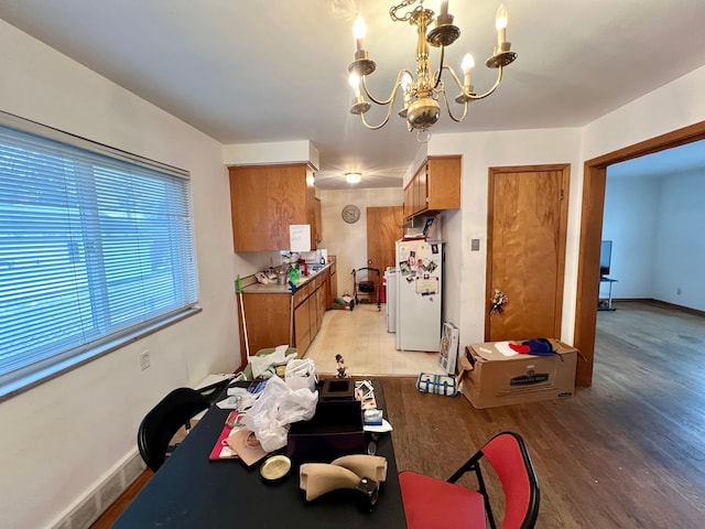 dining space featuring hardwood / wood-style flooring and an inviting chandelier