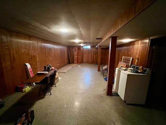 basement featuring wood walls and washer / dryer