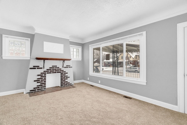 unfurnished living room with a tiled fireplace, crown molding, carpet floors, and a textured ceiling