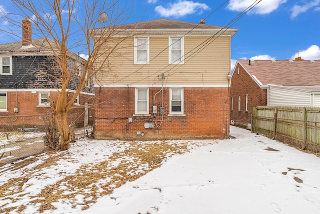 view of snow covered rear of property