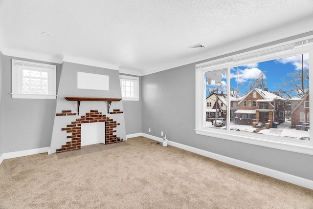 unfurnished living room with crown molding, light colored carpet, a fireplace, and a textured ceiling