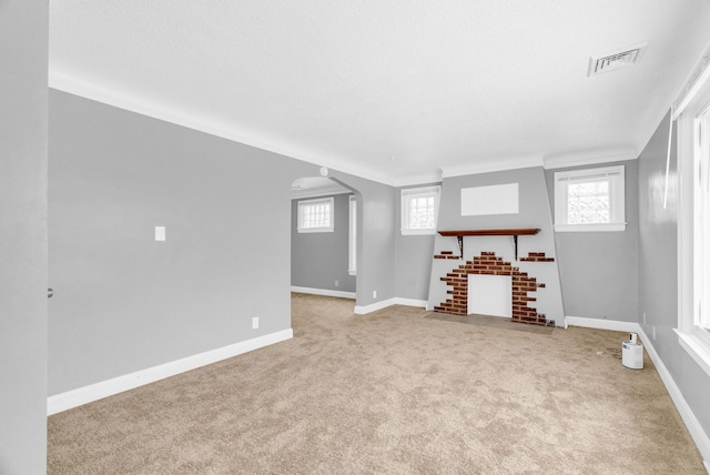 unfurnished living room featuring crown molding, light carpet, and a textured ceiling