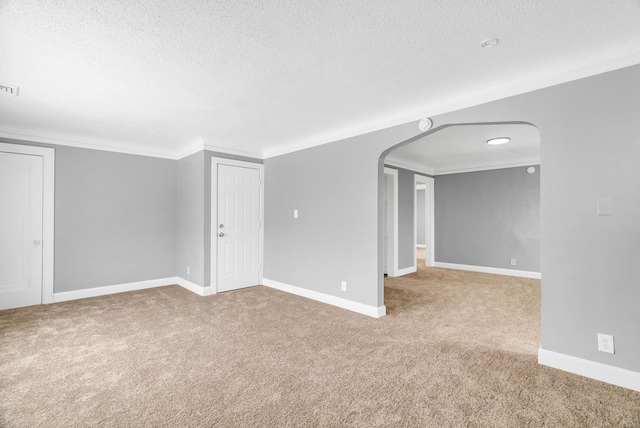 carpeted empty room with crown molding and a textured ceiling