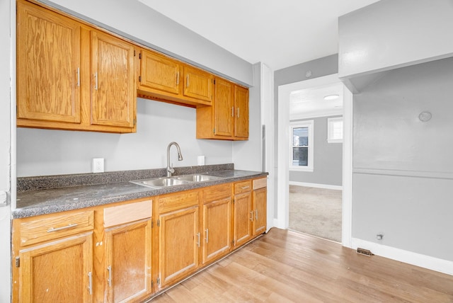 kitchen with sink and light hardwood / wood-style flooring